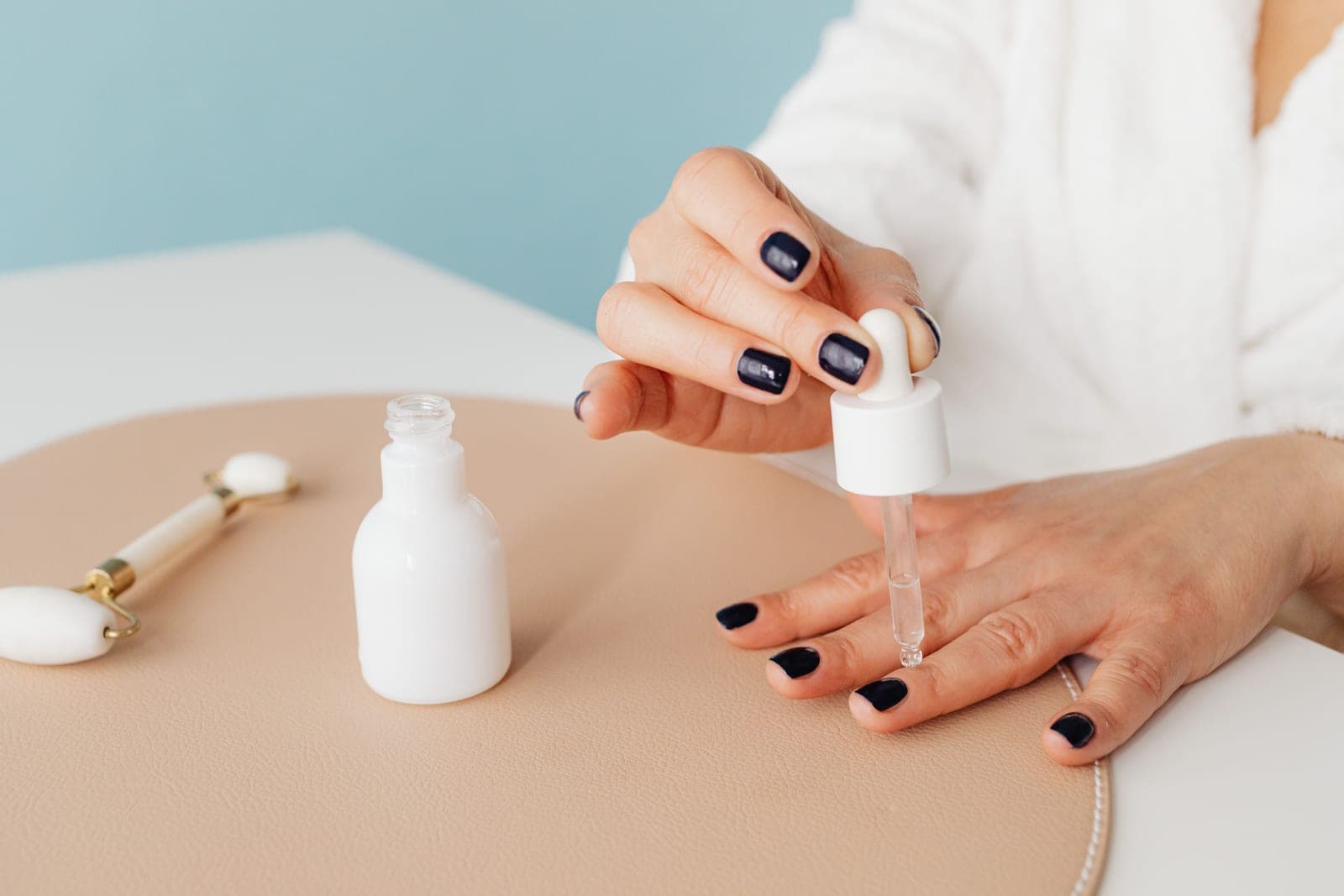 Cuticle oil being applied to the base of a fingernail