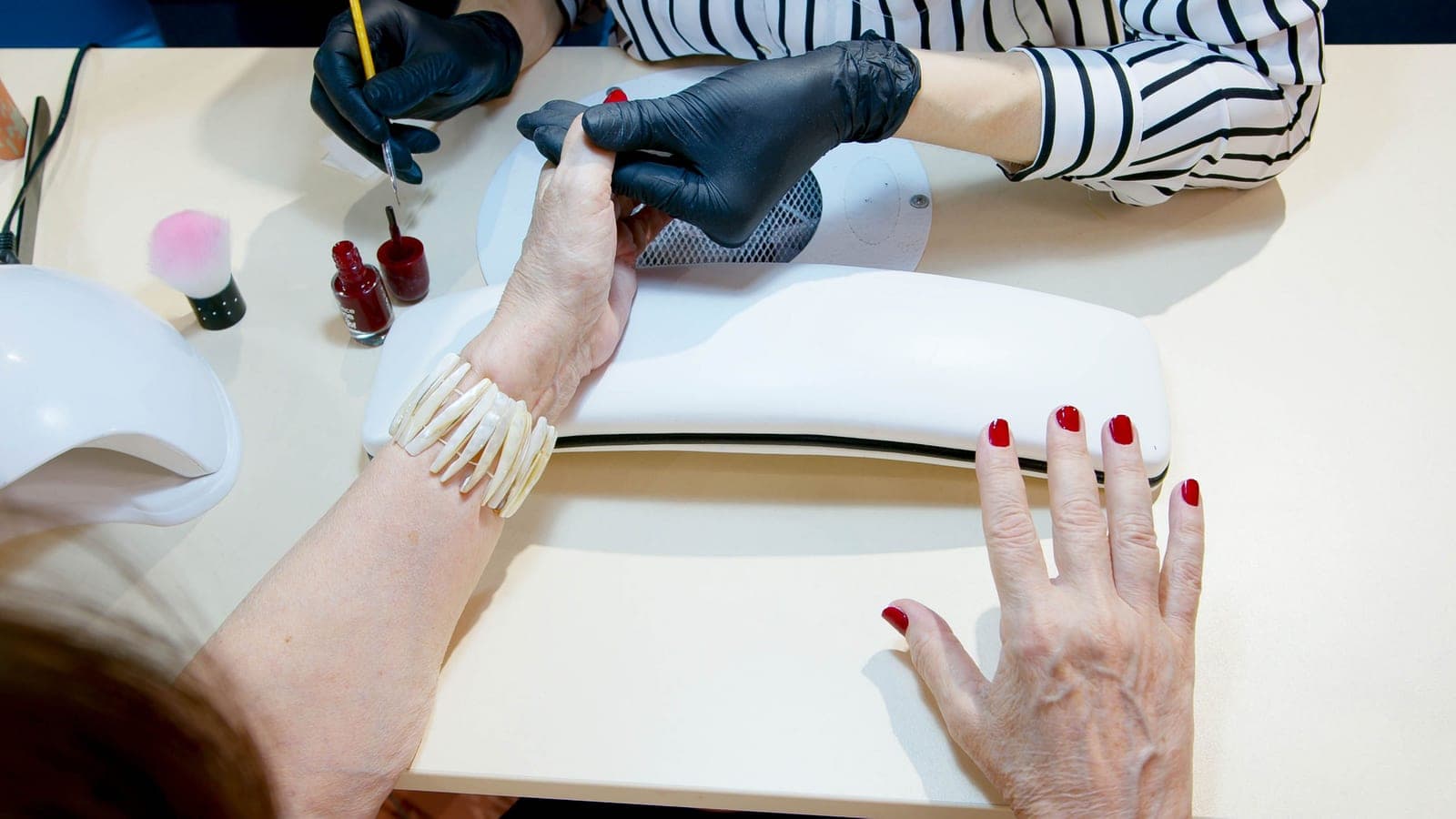 Gel polish being applied to a fingernail with a brush