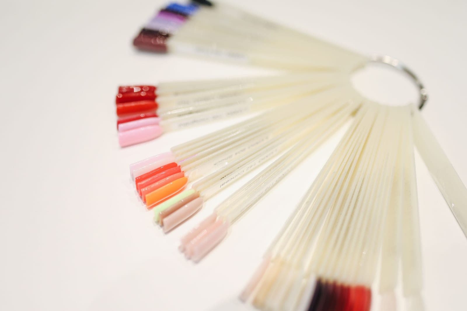 A set of press-on nail tips arranged on a pale surface